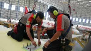 Engineers install the Inmarsat GX Aviation satellite kit atop an Avianca A320 (Image via Inmarsat)