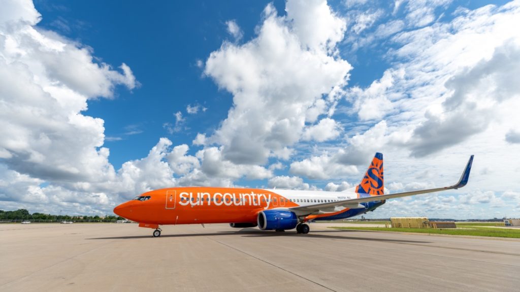 mostly orange plane parked at an airport