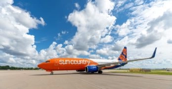 mostly orange plane parked at an airport