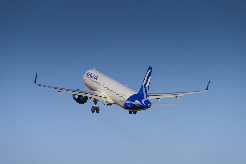 An Aegean A321neo flying away into blue skies