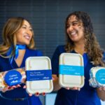 Flight attendants celebrating the return of hot food options for Alaska Airlines' economy class passengers