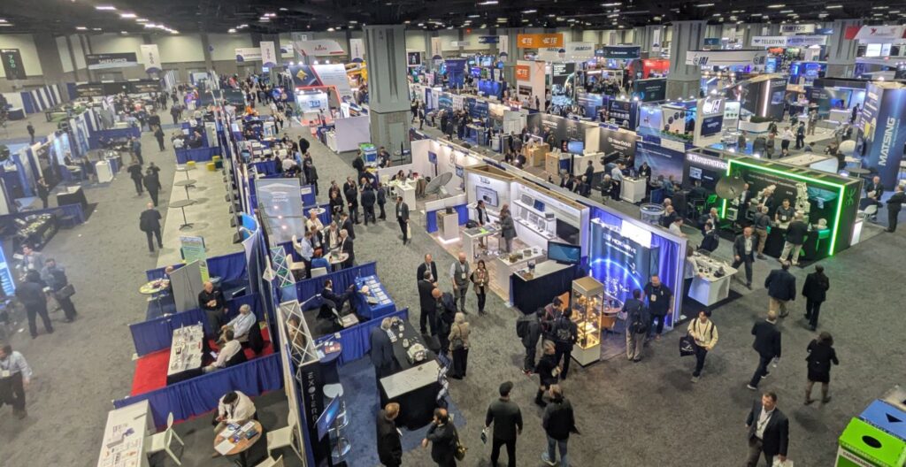 looking down on a trade show floor with lots of booths and people.