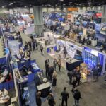 looking down on a trade show floor with lots of booths and people.