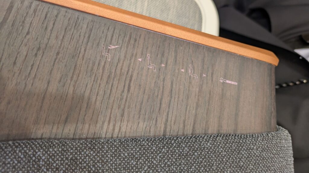 Control buttons for the seat, semi-hidden in the wood grain and terrible to use.