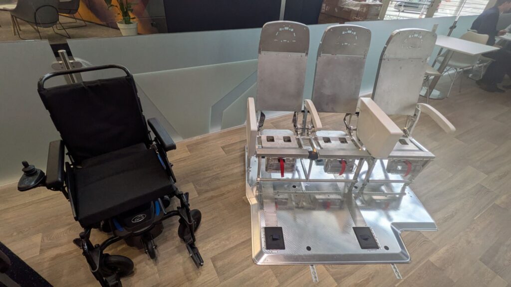 Wheelchair next to the metal frame of a triple set of seats.
