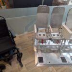 Wheelchair next to the metal frame of a triple set of seats.