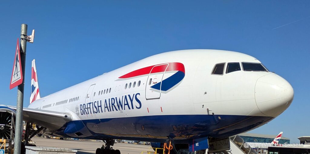 A British Airways 777 with its white fuselage and blue belly, parked on the ground at Heathrow
