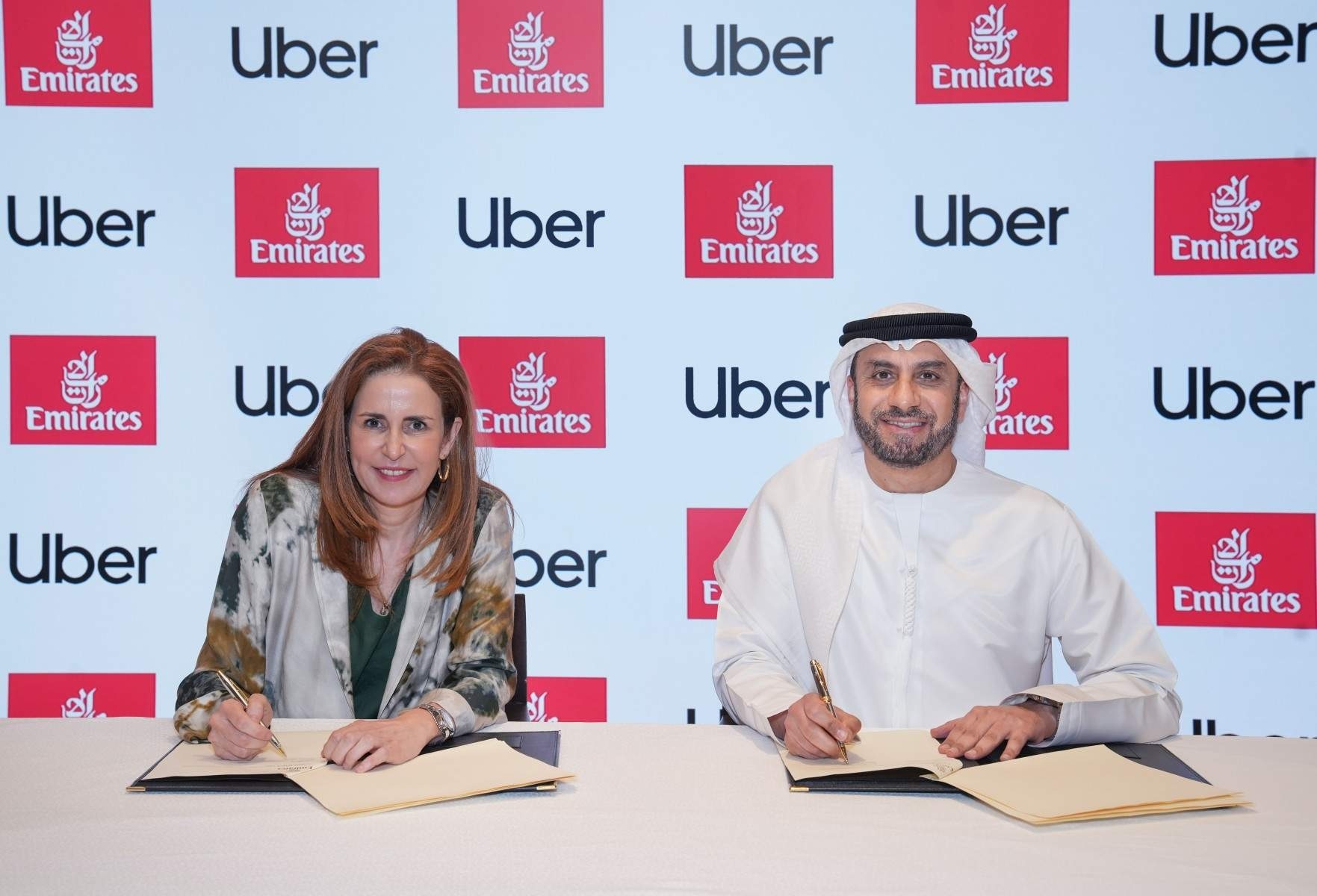 Uber and Emirates executives signing a MoU to pursue a partnership