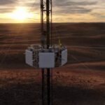 cell tower in a field at sunset