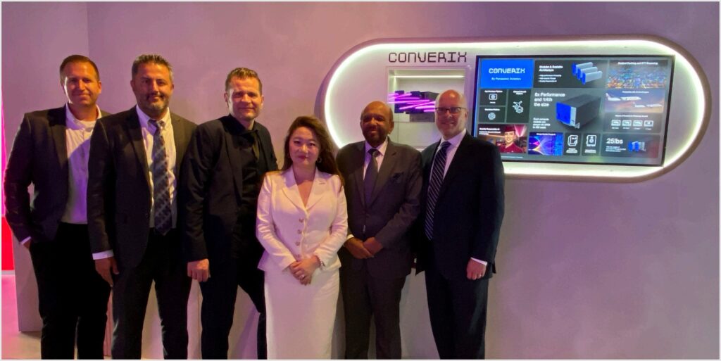 Bunch of people standing together in a trade show booth.