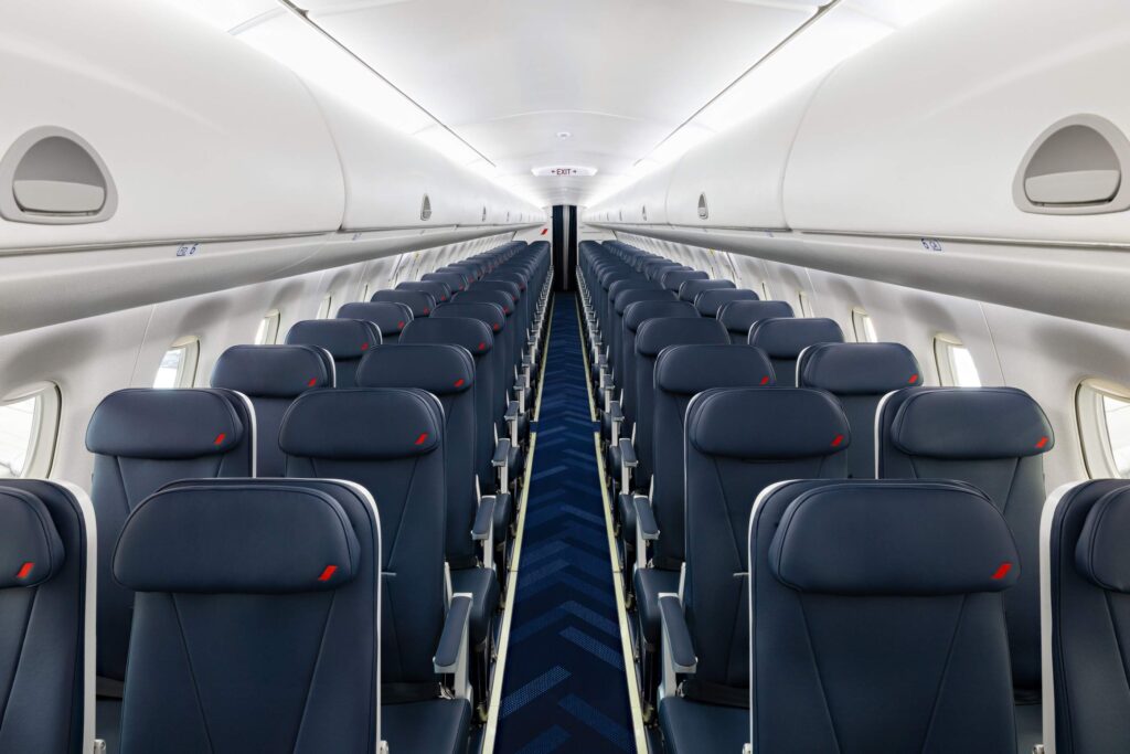 Blue seats in a 2-2 arrangement in the airplane.
