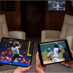business jet passengers watching on their tablets while a screen on the bulkhead shows a different channel.