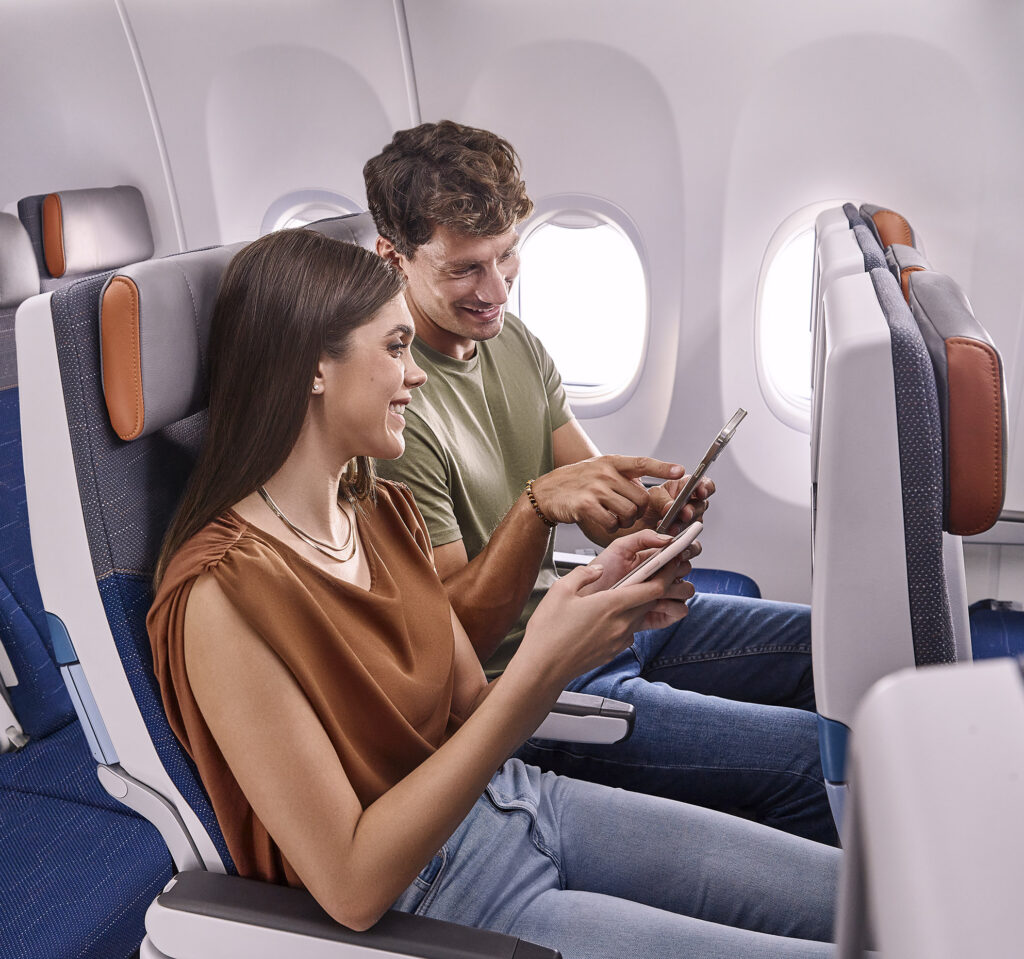 A couple using their personal devices in a flydubai cabin