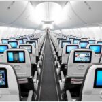 lots of screens on economy class seats in a 3-3 layout