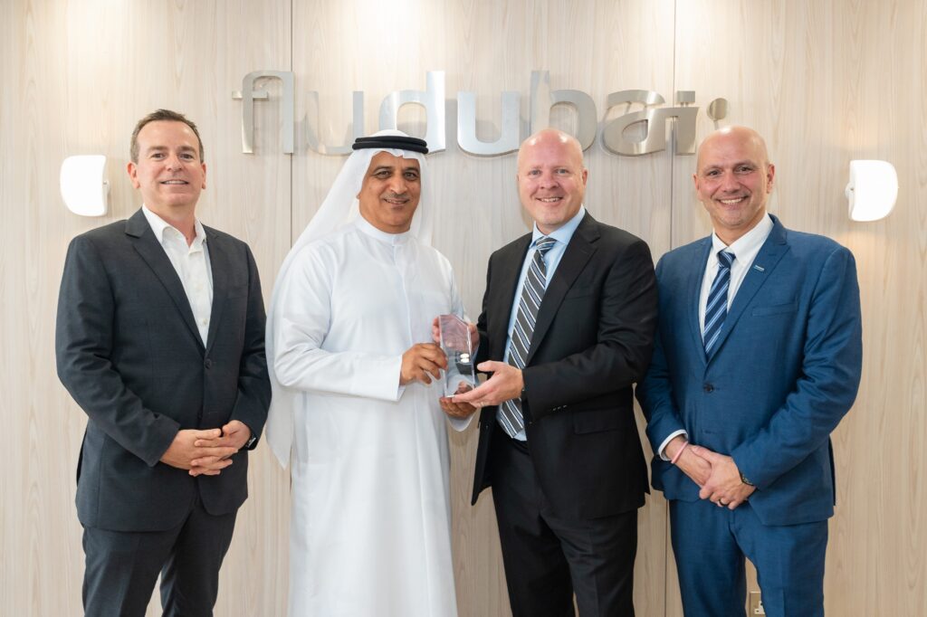 Four guys in front of a flydubai logo on the wall