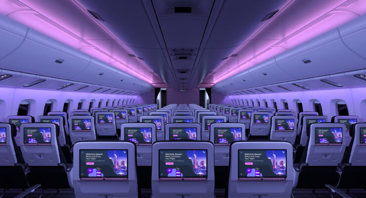 IFE screens in airplane seats in a darkened cabin