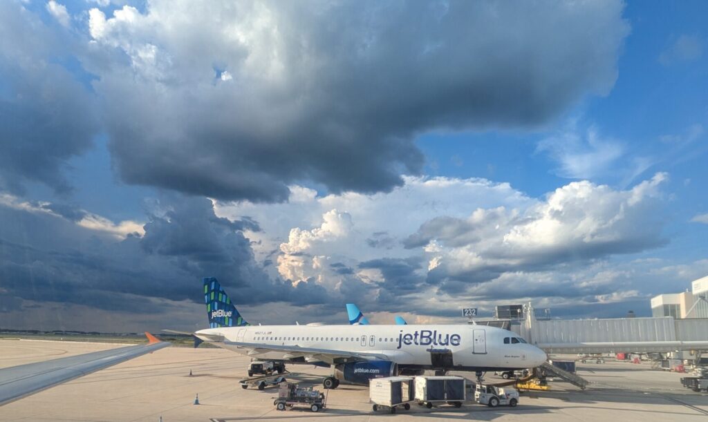 Storm clouds over JetBlue planes at an airport