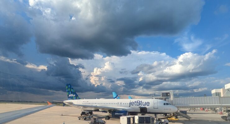 Storm clouds over JetBlue planes at an airport
