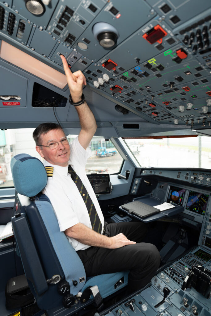 Airline pilot pointing to the power switch on the flight deck console for the inflight  internet service