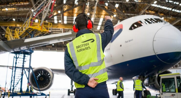 Ground handler monitoring a 787 being pulled into the hangar for the Starlink installation