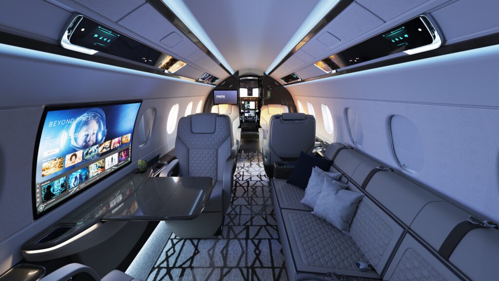 Interior of Embraer's Praetor 600E, including a giant curved screen built in to the fuselage and showing entertainment options.