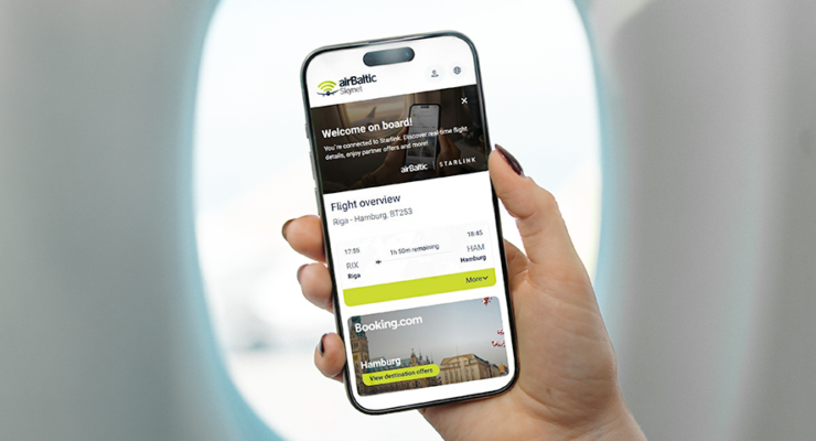 hand holding an iPhone in front of a plane window. The screen shows the new airBaltic shopping portal, including flight details and an option to book a hotel via a partner.
