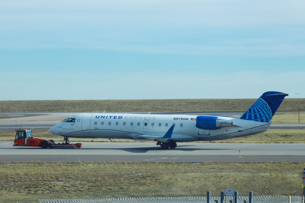 A United Express CRJ200 being towed at Denver