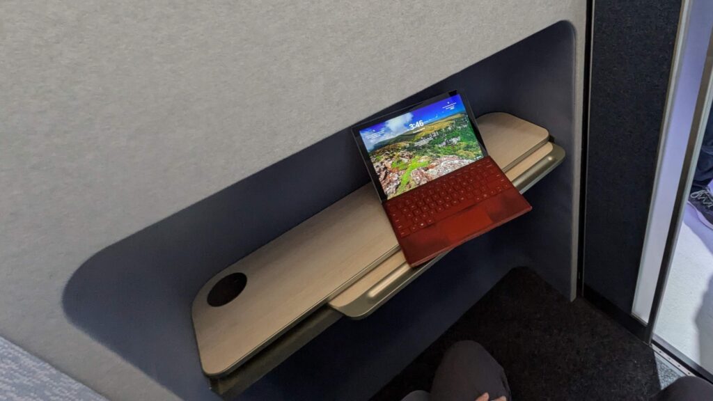 Laptop on a small desk in the work pod.