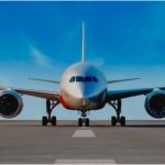 nose-on view of a 787 on the ramp with blue skies behind.