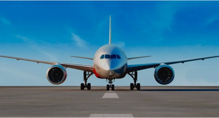 nose-on view of a 787 on the ramp with blue skies behind.