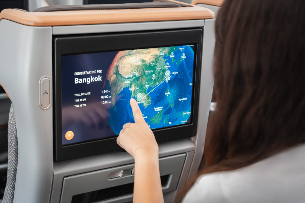 Woman interacting with the Arc inflight map on a seat-back screen