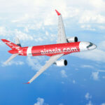 rendering of the A220 in AirAsia's red livery, flying in blue skies with a few clouds