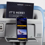 Mobile phone on a Southwest seatback device holder, advertising the carrier's new Starlink inflight internet service