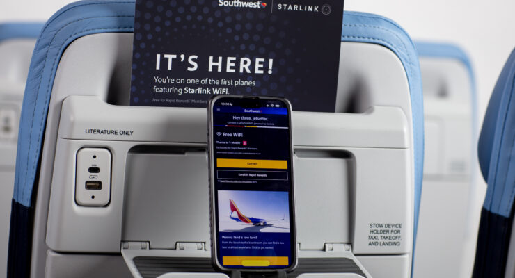 Mobile phone on a Southwest seatback device holder, advertising the carrier's new Starlink inflight internet service