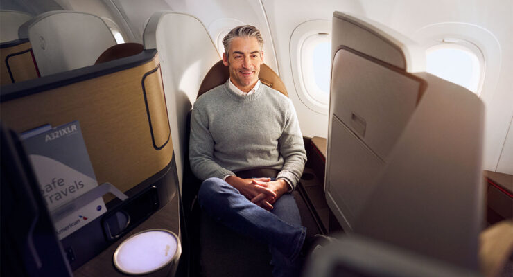 Guy sitting in a narrow business class seat on a plane