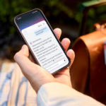 A hand holding a mobile phone using the 