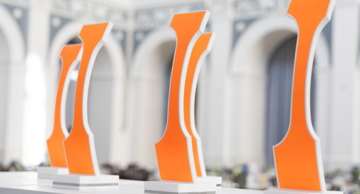 Trophies backed in bright orange on a display table