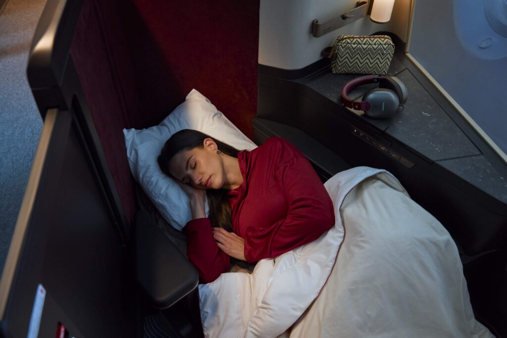 woman sleeping in a lie-flat airplane seat.
