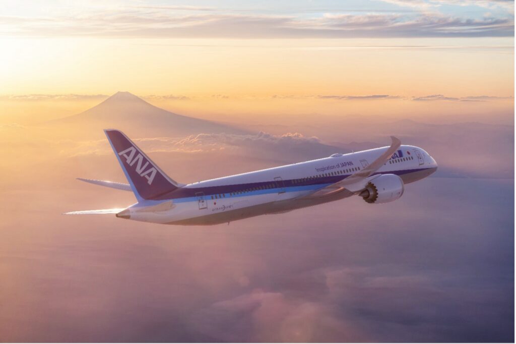 ANA jet flying at golden hour above the clouds